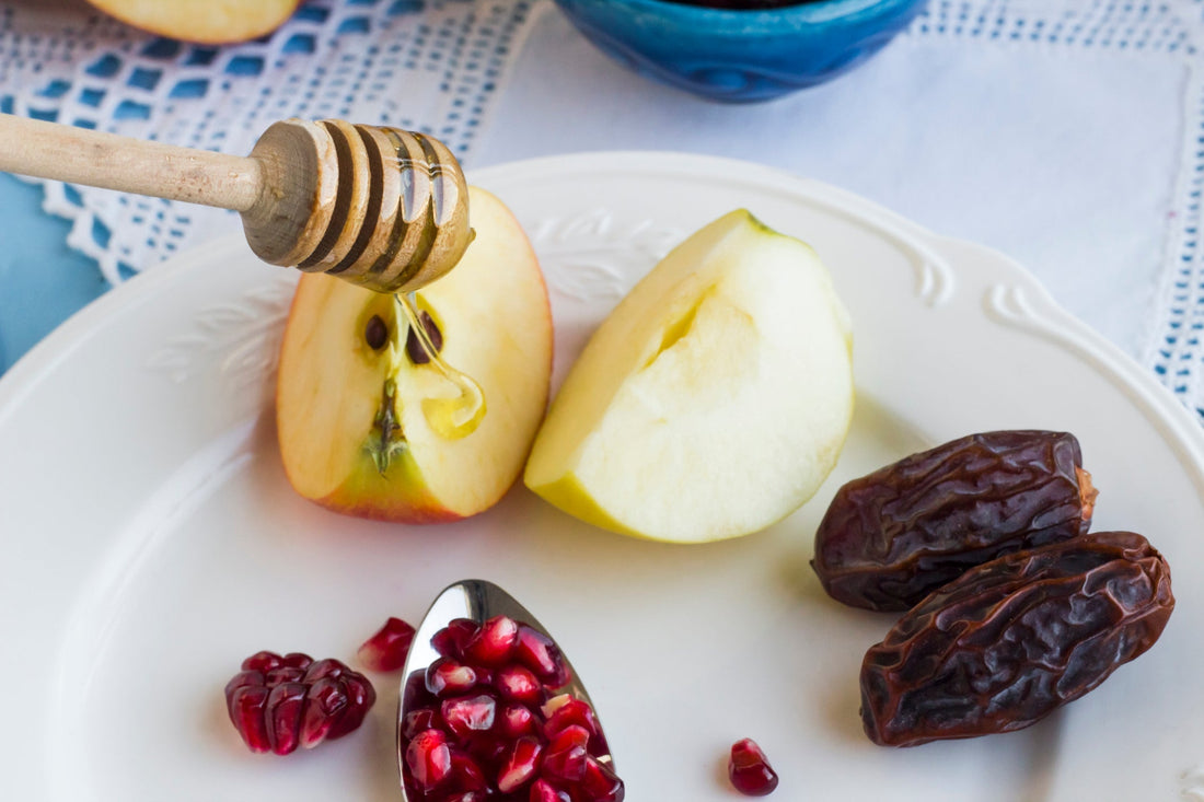 Plate with apples, honey, dates, and pomegranate seeds